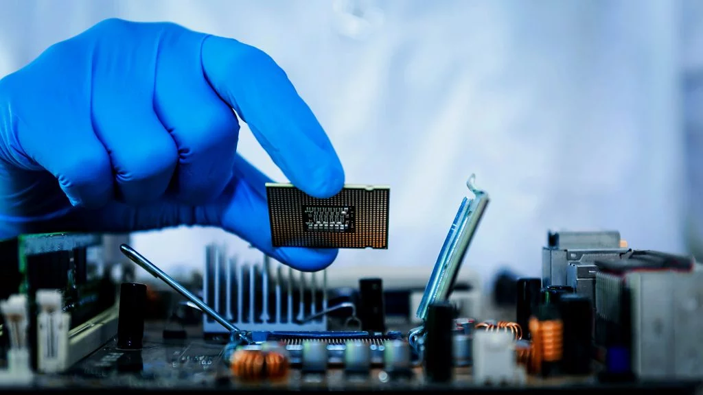 Photo of gloved hand holding microchip - Integrity Cleanroom